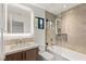 Modern bathroom with a glass-enclosed tub/shower and vanity with lighted mirror at 2316 Prometheus Ct, Henderson, NV 89074