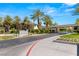 The Fountains community entrance with palm trees, landscaping, and a security gate on a sunny day at 2316 Prometheus Ct, Henderson, NV 89074