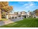 Beautiful home showcasing a well-maintained lawn, arched windows, and a three-car garage at 2316 Prometheus Ct, Henderson, NV 89074