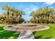 Community fountain encircled by palm trees, landscaping, and a walkway on a sunny day at 2316 Prometheus Ct, Henderson, NV 89074