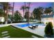 Resort-style pool with a built-in spa, surrounded by lush landscaping and comfortable lounge chairs at 2316 Prometheus Ct, Henderson, NV 89074