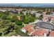Expansive aerial view of community, home, and park with lush trees and Las Vegas skyline in the distance at 2501 Muirfield Ave, Henderson, NV 89074
