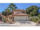 Charming two-story home with a tile roof, a two-car garage, and mature landscaping featuring palm trees at 2501 Muirfield Ave, Henderson, NV 89074