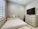 Serene bedroom with neutral color scheme, dresser with a TV, creating a relaxing atmosphere at 253 Malpaso St, Las Vegas, NV 89138