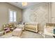 Cozy Bedroom with a crib, patterned accent wall, comfortable armchair, and ample natural light, creating a serene space at 253 Malpaso St, Las Vegas, NV 89138