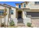 Charming home featuring a stone facade, arched entryway, and a beautifully landscaped front yard at 253 Malpaso St, Las Vegas, NV 89138