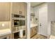 Gourmet kitchen featuring modern stainless steel double ovens, light wood cabinetry, and herringbone backsplash at 253 Malpaso St, Las Vegas, NV 89138