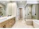 A luxurious main bathroom featuring double sinks, a soaking tub, and a glass-enclosed shower at 253 Malpaso St, Las Vegas, NV 89138