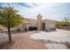 Back of house with low maintenance landscaping, mature trees and a large patio area at 2737 Tumble Brook Dr, Las Vegas, NV 89134