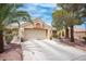 Inviting single-story home with a two-car garage, desert landscape, mature trees, and a tile roof at 2737 Tumble Brook Dr, Las Vegas, NV 89134