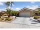 Charming single-story home featuring a two-car garage, desert landscaping, and mature palm trees in a well-maintained front yard at 3016 High Range Dr, Las Vegas, NV 89134
