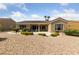 Expansive backyard with desert landscaping, a covered patio, and lush green plants, ideal for entertaining or relaxation at 3016 High Range Dr, Las Vegas, NV 89134