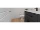 Modern half-bathroom with wood floors, a dark vanity, toilet, and a stylish faucet at 3038 Villanelle Ave, Henderson, NV 89044