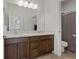 Well-lit bathroom with a double sink vanity, dark wood cabinets, and a shower/toilet room at 3038 Villanelle Ave, Henderson, NV 89044