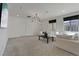 Comfortable carpeted living room with modern light fixture and large windows offering ample natural light at 3038 Villanelle Ave, Henderson, NV 89044