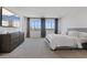 Well-lit main bedroom features large windows, stylish grey curtains, and a modern dresser under the large TV at 3038 Villanelle Ave, Henderson, NV 89044