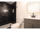 Modern bathroom featuring black marble tiled walls, shower, and a gray vanity at 3115 Wright Ave, North Las Vegas, NV 89030