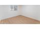 Minimalist bedroom with neutral walls, wood-look floors, and a window allowing natural light at 3320 Osage Ave, Las Vegas, NV 89101