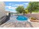 Backyard with a beautiful in-ground pool, concrete patio, privacy wall, and mature landscaping at 3320 Osage Ave, Las Vegas, NV 89101