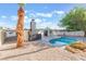 In-ground pool with ladder, concrete patio, gravel landscaping, and a brick fireplace at 3320 Osage Ave, Las Vegas, NV 89101