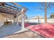 A beautiful red basketball court with pillars and a pergola overlooking the court in a backyard setting at 3382 Montessouri, Las Vegas, NV 89117