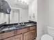 Bathroom with dark-tile countertops, wood cabinets, and a toilet at 3382 Montessouri, Las Vegas, NV 89117