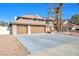 Exterior view of a home showcasing a large three-car garage and low-maintenance desert landscaping at 3382 Montessouri, Las Vegas, NV 89117