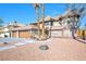 Charming exterior of a home featuring a three-car garage, mature palm trees and desert landscaping at 3382 Montessouri, Las Vegas, NV 89117