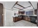 Well-lit kitchen featuring dark wood cabinetry, tiled countertops, and modern appliances at 3382 Montessouri, Las Vegas, NV 89117
