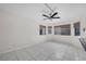 Bright living area with large windows, white tiled floors, and modern ceiling fan at 3382 Montessouri, Las Vegas, NV 89117