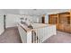 Open loft area with carpet, built-in bookshelves, and stair access at 3382 Montessouri, Las Vegas, NV 89117