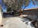 Backyard featuring concrete patio, mature trees, and block wall, perfect for entertaining and relaxation at 3429 Back Country Dr, North Las Vegas, NV 89031