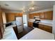 Well-lit kitchen with white appliances, tile countertops, wooden cabinets, and tile flooring at 3429 Back Country Dr, North Las Vegas, NV 89031