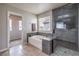 Bathroom with a soaking tub, sleek glass-enclosed shower, and large window at 3731 Prairie Orchid Ave, North Las Vegas, NV 89081