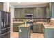 Modern kitchen featuring olive cabinets, granite countertops, stainless steel appliances, and stylish tile backsplash at 3731 Prairie Orchid Ave, North Las Vegas, NV 89081