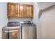 Laundry room featuring wooden cabinets and stainless steel washer and dryer at 3731 Prairie Orchid Ave, North Las Vegas, NV 89081