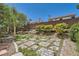 Beautiful backyard with a patio, lush greenery, flowering shrubs, and a privacy wall, perfect for outdoor enjoyment at 3749 Climbing Rose St, Las Vegas, NV 89147