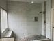 Sleek bathroom shower with marble-look tiles, mosaic accents, a built-in bench, and modern fixtures at 3749 Climbing Rose St, Las Vegas, NV 89147