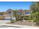 Elegant two-story home boasting manicured landscaping with decorative rock and mature palm trees at 3749 Climbing Rose St, Las Vegas, NV 89147