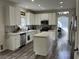 Modern kitchen with white cabinets, stainless steel appliances, a center island, and wood-look floors at 3749 Climbing Rose St, Las Vegas, NV 89147