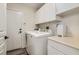 Bright laundry room featuring white cabinets, washer, and dryer at 3749 Climbing Rose St, Las Vegas, NV 89147