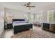 Sunlit primary bedroom with ceiling fan, two windows and dresser at 3749 Climbing Rose St, Las Vegas, NV 89147
