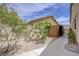 Enclosed backyard space with wood shed, stone landscaping, and walkway to side gate at 3760 Candytuft Ridge Ave, North Las Vegas, NV 89081
