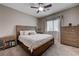 Comfortable bedroom featuring a wooden bed frame, ceiling fan, and ample natural light from the window at 3760 Candytuft Ridge Ave, North Las Vegas, NV 89081