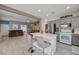 Bright kitchen featuring stainless appliances, white marble island with seating, and a view to the living room at 3760 Candytuft Ridge Ave, North Las Vegas, NV 89081