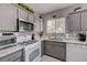 Well-lit kitchen featuring gray cabinets, white countertops, and stainless steel appliances with a window at 3760 Candytuft Ridge Ave, North Las Vegas, NV 89081