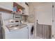 Efficient laundry room features modern washer and dryer, stylish tile backsplash, and ample storage cabinets at 3760 Candytuft Ridge Ave, North Las Vegas, NV 89081