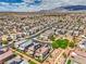 Broad aerial perspective highlighting a neighborhood with desert landscaping, solar roofs, and mountain backdrop at 415 Carsin Wayne Ct, North Las Vegas, NV 89031