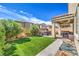 Spacious backyard featuring artificial turf, mature landscaping, covered patio, and a relaxing spa at 415 Carsin Wayne Ct, North Las Vegas, NV 89031