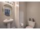 Neutral powder room with pedestal sink, round mirror, and toilet; stairs are visible in the mirror's reflection at 415 Carsin Wayne Ct, North Las Vegas, NV 89031